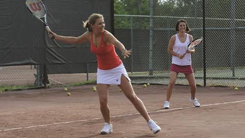Women play tennis on red clay courts at Stratton Mountain Resort
