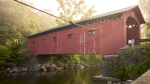 a scenic covered bridge over a river in Vermont