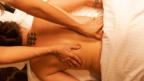 guest enjoying a back massage at stratton resort's spa, offering relaxing massage services in a peaceful setting