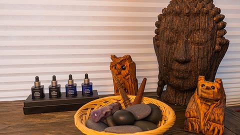 massage oils and hot stones arranged on a wooden table at stratton resort's wellness space