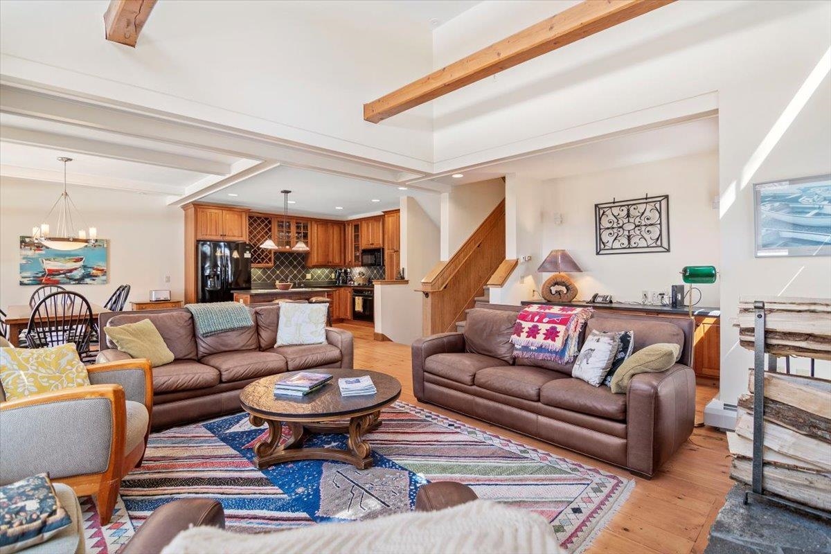 Open-concept Stratton Mountain home with leather sofas, dining area, and gourmet kitchen, perfect for Vermont real estate buyers seeking spacious vacation homes