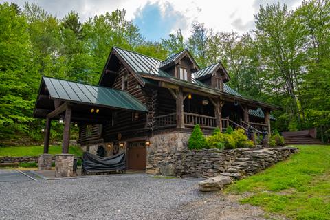 Rustic timber frame single family home with covered porch and stone accents, located in the Beaver Street community near Stratton Mountain Resort