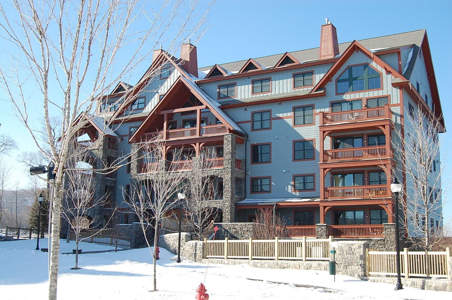 Snow covered exterior of Hearthstone at 761 Stratton Mountain Access Road, showcasing a multi-story lodge-style building in the heart of Stratton Resort's Vermont real estate listings