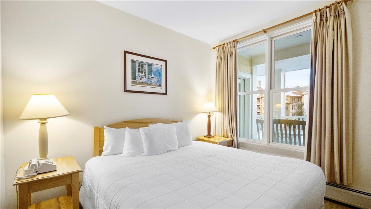 corner bedroom with large windows private balcony and natural light in long trail house unit a vermont real estate property at stratton mountain