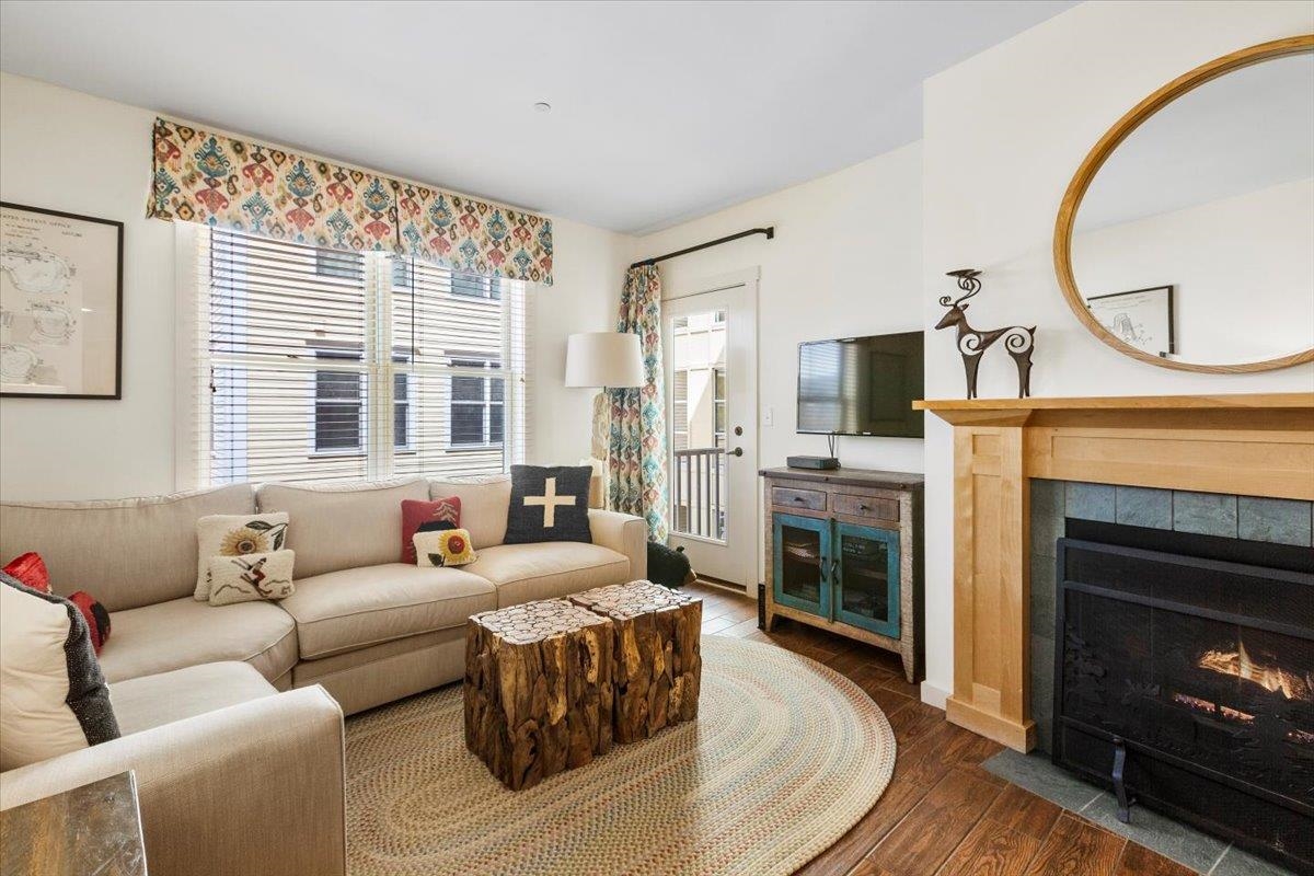 Bright and inviting living room with fireplace and rustic accents at Long Trail House, part of Stratton’s Vermont real estate offerings
