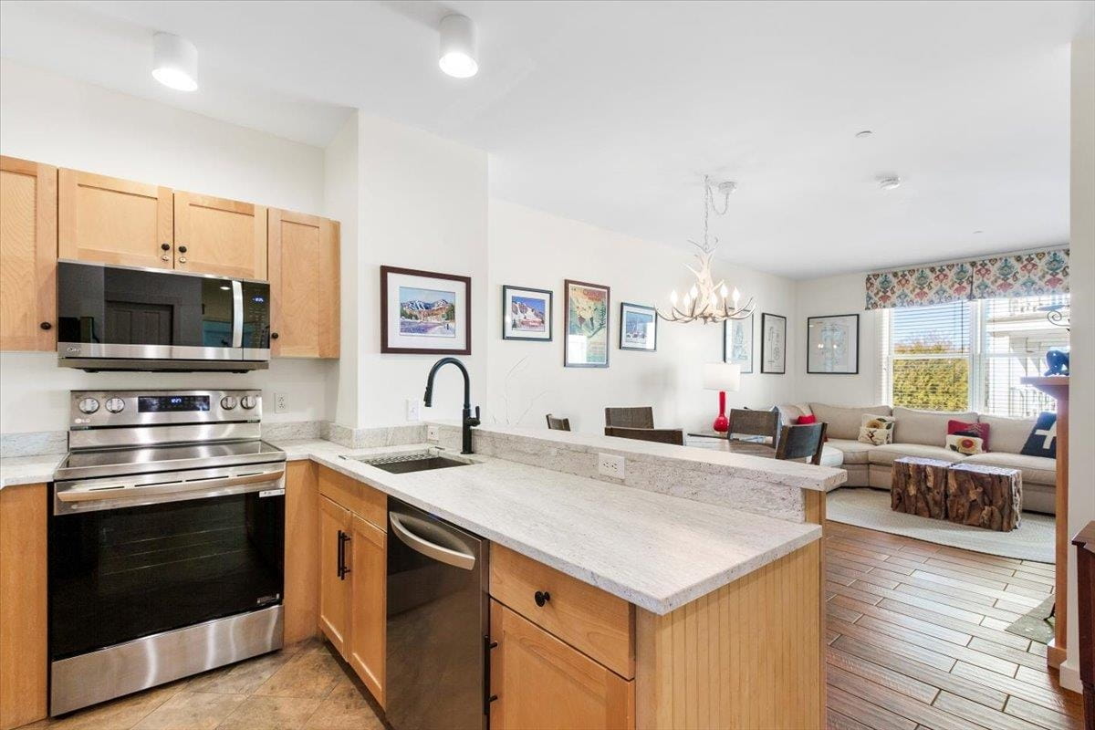 Updated kitchen and bright living area with wood-look tile flooring and mountain decor at Long Trail House, a featured listing in Vermont real estate at Stratton Mountain