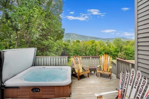Deck with private hot tub and Adirondack chairs overlooking Stratton Mountain, ideal for Vermont vacation rentals or real estate in Stratton