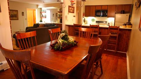 Interior view of the kitchen and dining area of a crown point vacation rental offered by stratton mountain hotels and vacation rentals
